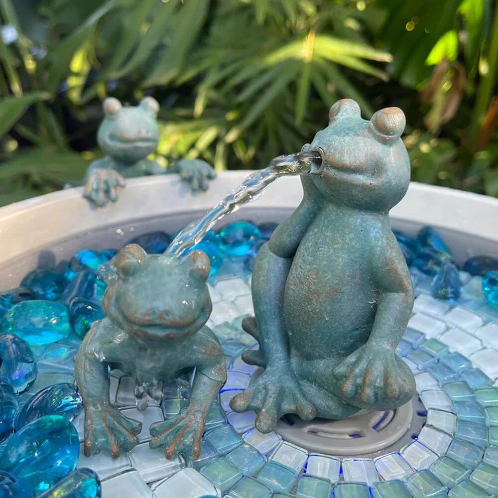 Frog-themed water fountain with decorative stones
