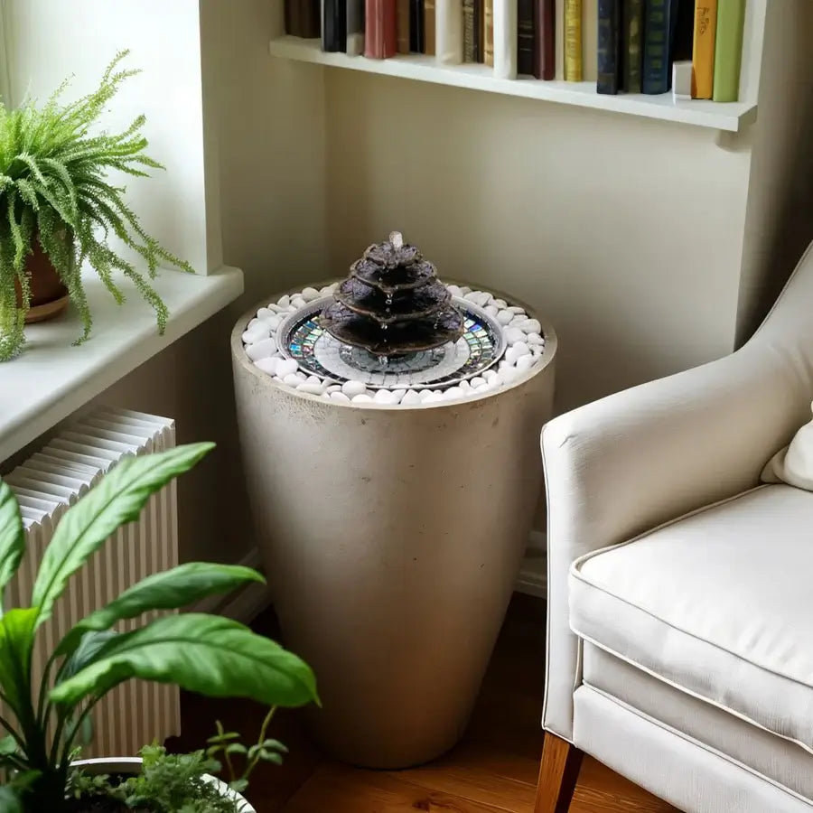 Hydria fountain in a plant pot in the corner by a chair
