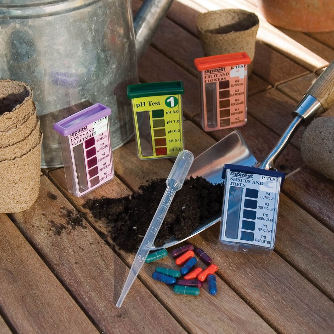 Gardening tools and pH test strips on a wooden surface
