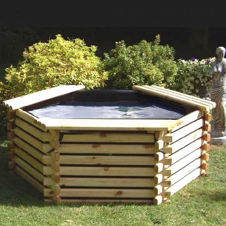 wooden pond in garden sat on grass with bushes in the background