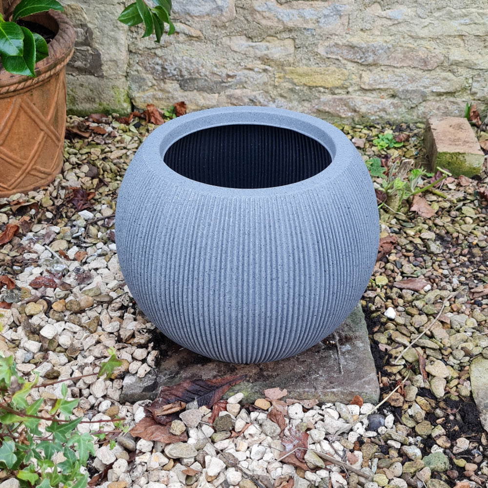 ridged stone ball planter in garden