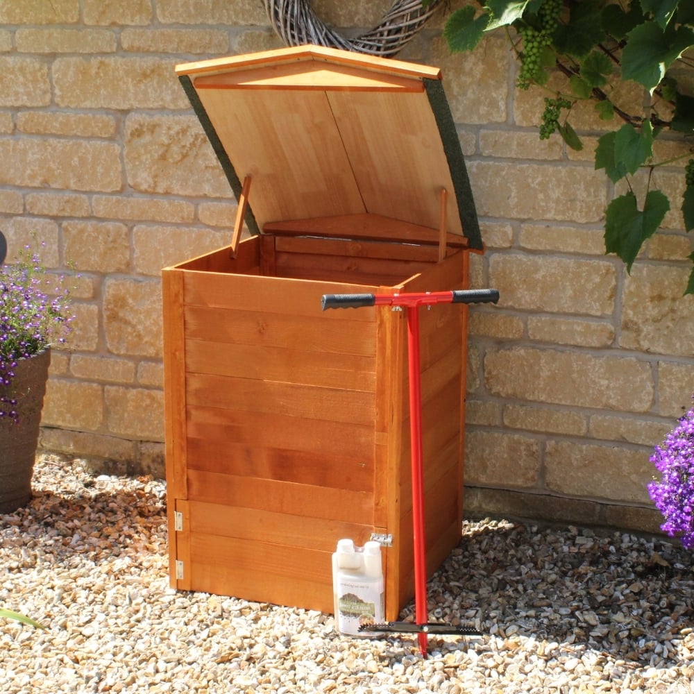 Beehive Wooden Compost bin on stones by a wall
