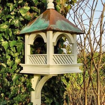 A green and white wooden bird table