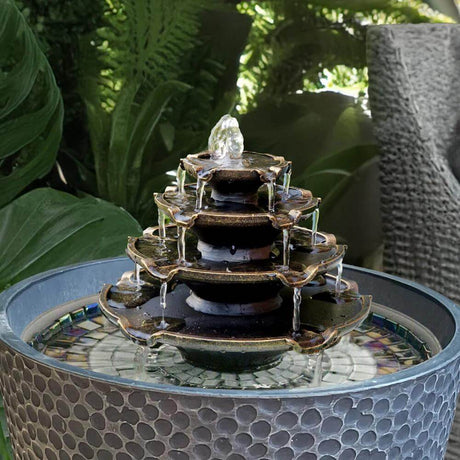 Decorative water fountain black in a garden pot