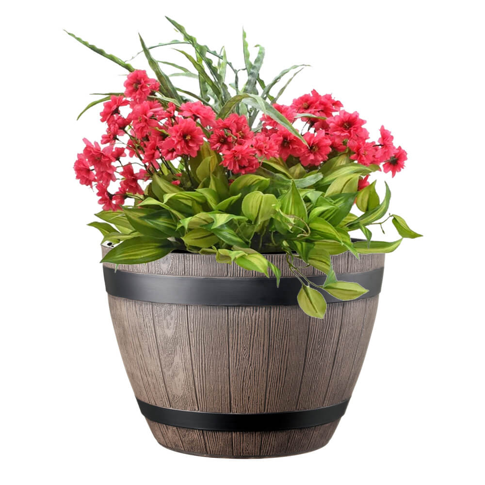 Wooden barrel planter with pink flowers and green leaves on a white background