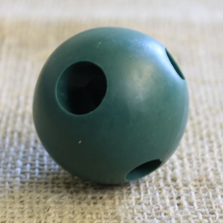 A green solid rubber build a ball with multiple holes for garden cage construction.