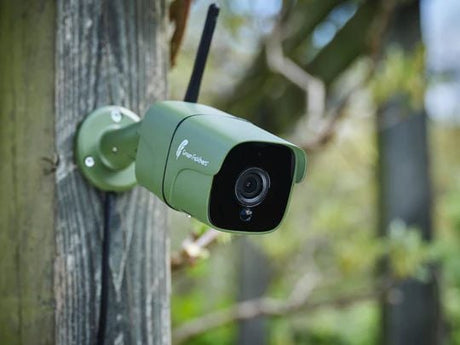 Wildlife camera on a wooden post in a garden