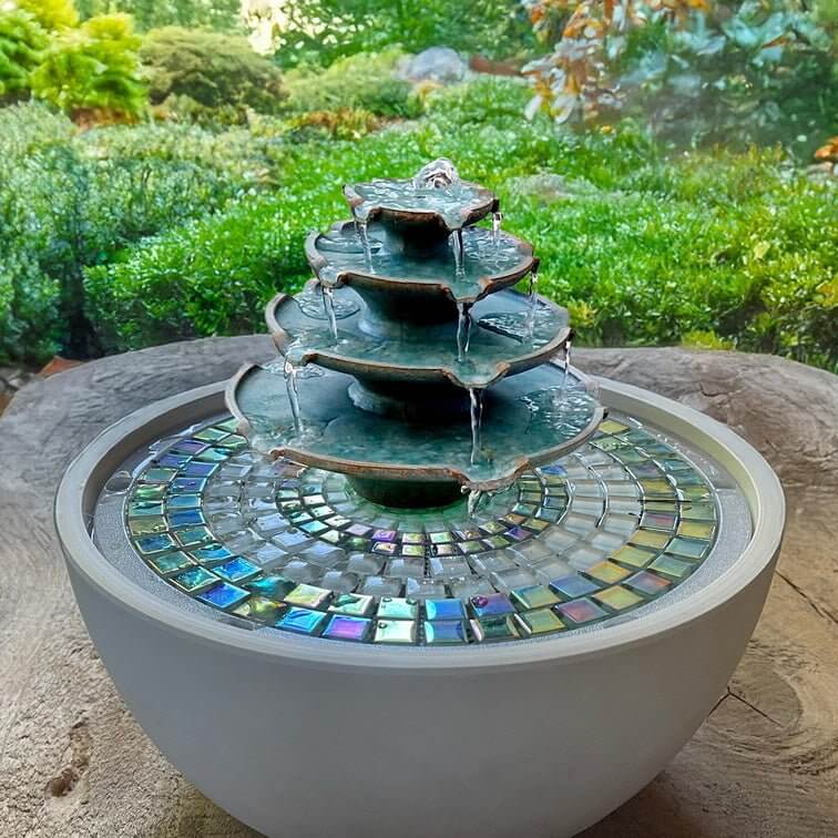 Three-tiered water fountain with mosaic tile base