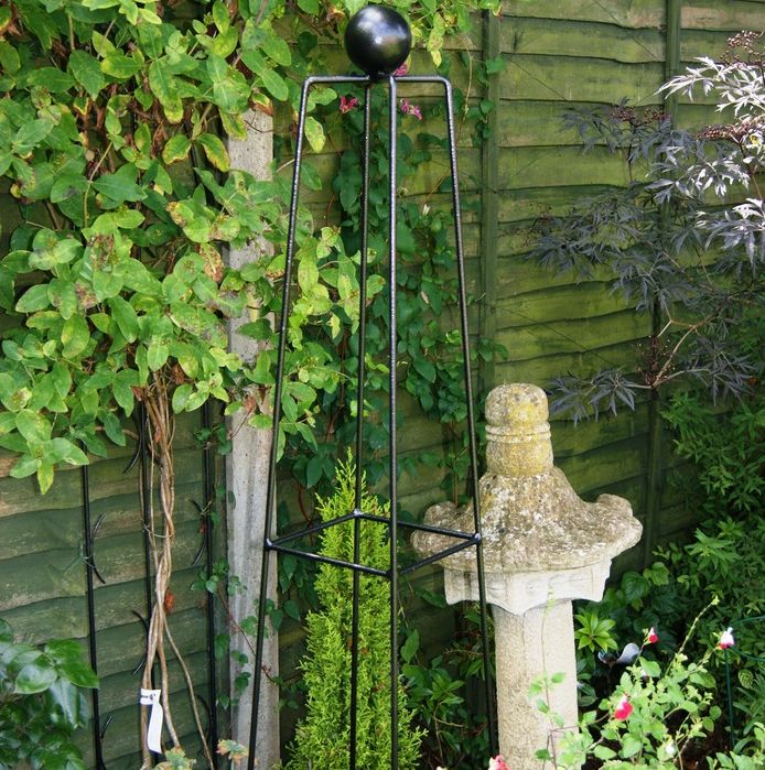 A black metal obelisk garden feature