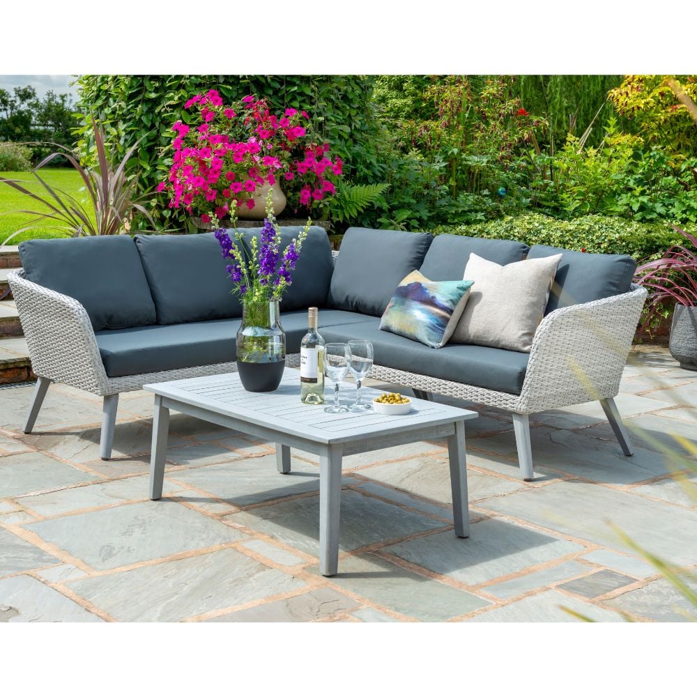 Corner sofa in garden with coffee table wine glasses on table