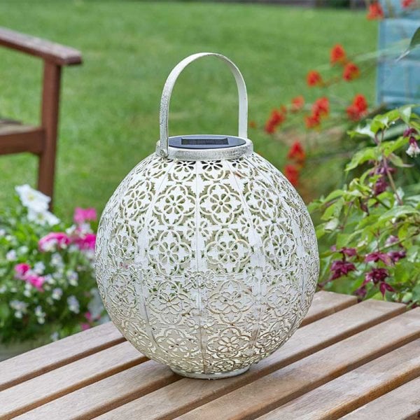Cream Moroccan style lantern stood on a table in garden