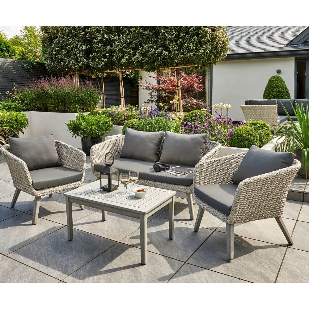 garden furniture with cushions and a glass of wine on table