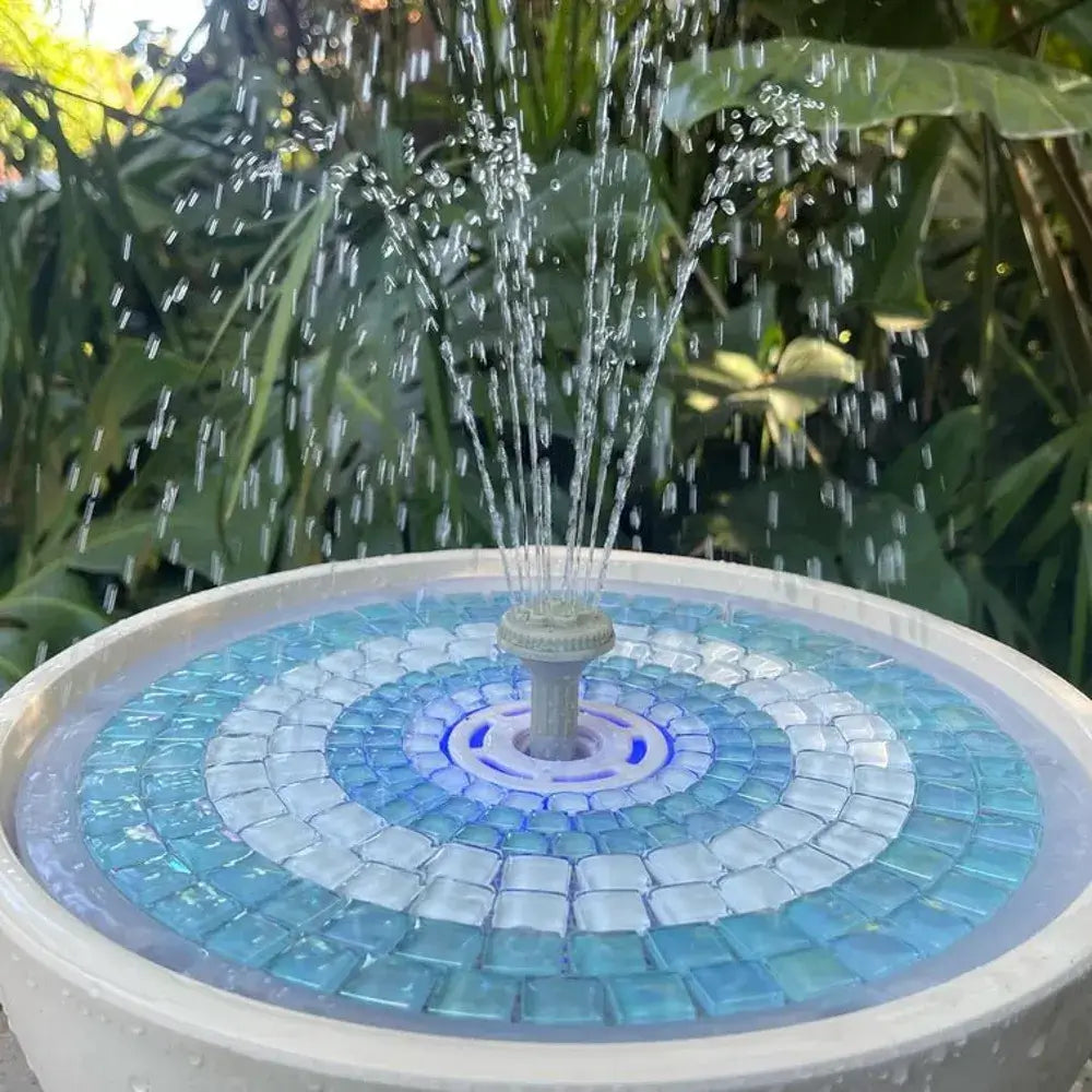 Mosaic water fountain with blue and white design in a garden setting