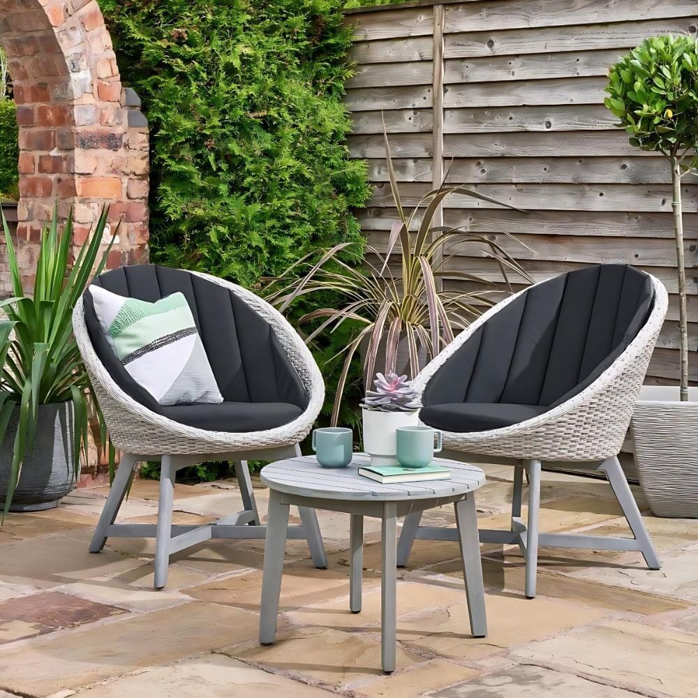Bistro set 2 egg chairs and one table with cushions set out in a nice garden