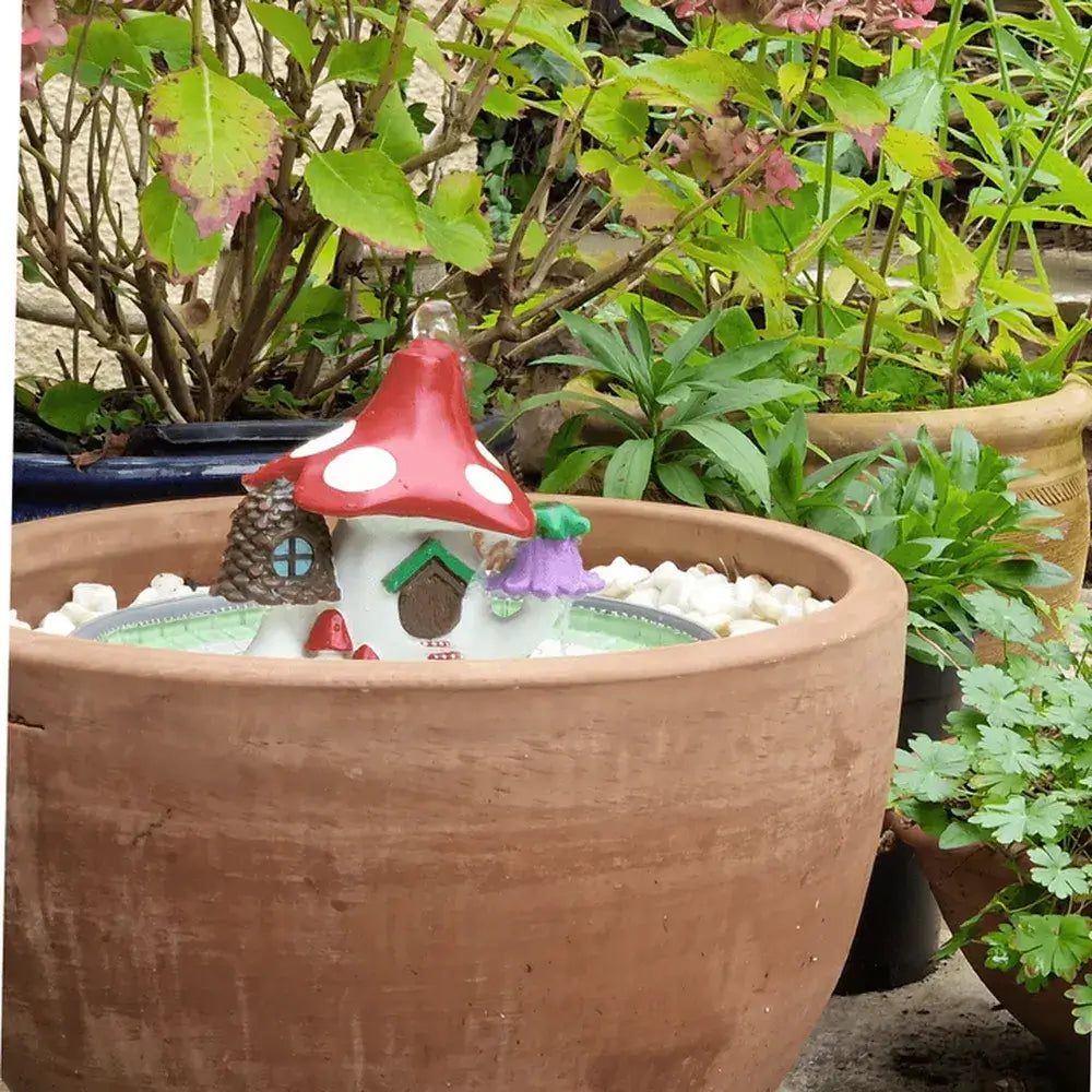 Fairy garden with a red mushroom-shaped house in a terracotta pot