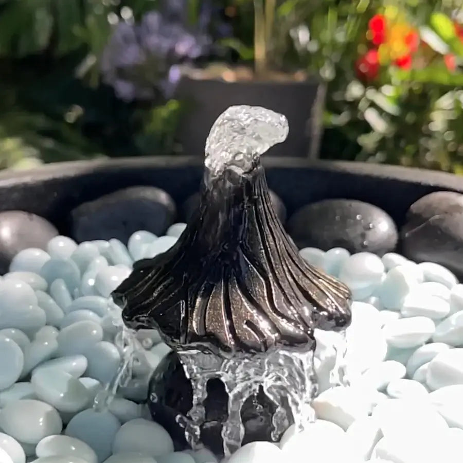 Decorative water feature with flowing water on pebbles