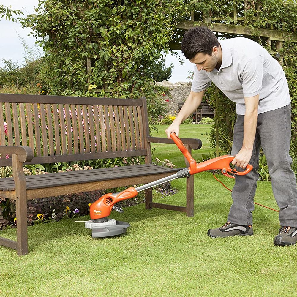flymo strimmer being used under garden seat