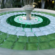 Mosaic fountain with green and white tiles and a central water feature.