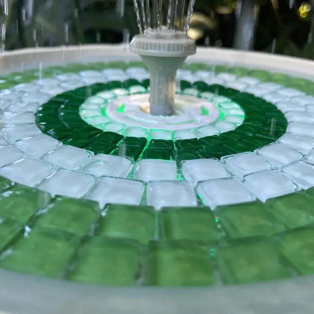 Mosaic fountain with green and white tiles and a central water feature.