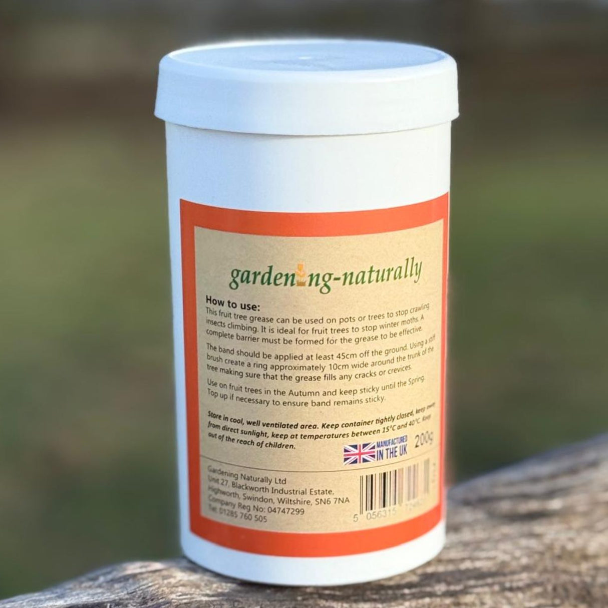 A white plastic container of gardening-naturally tree bark fruit tree grease with instructions