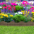 A brown, curved garden border made from recycled rubber, installed around a bed of colorful flowers.