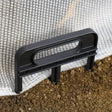 Black plastic tool on soil with a white fabric background