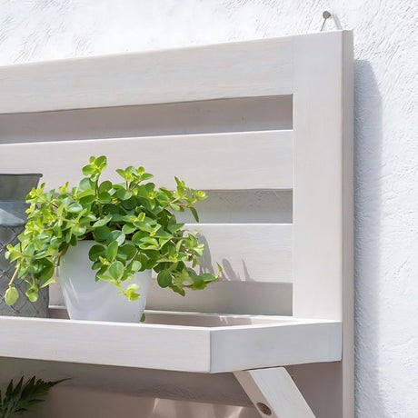 garden shelf on wall with plant pots on in garden