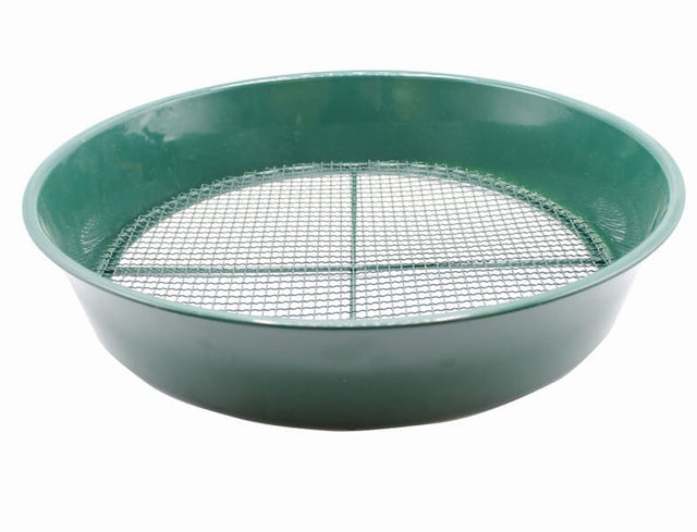 A green metal soil sieve with fine mesh used for sifting and breaking up clumps of soil.