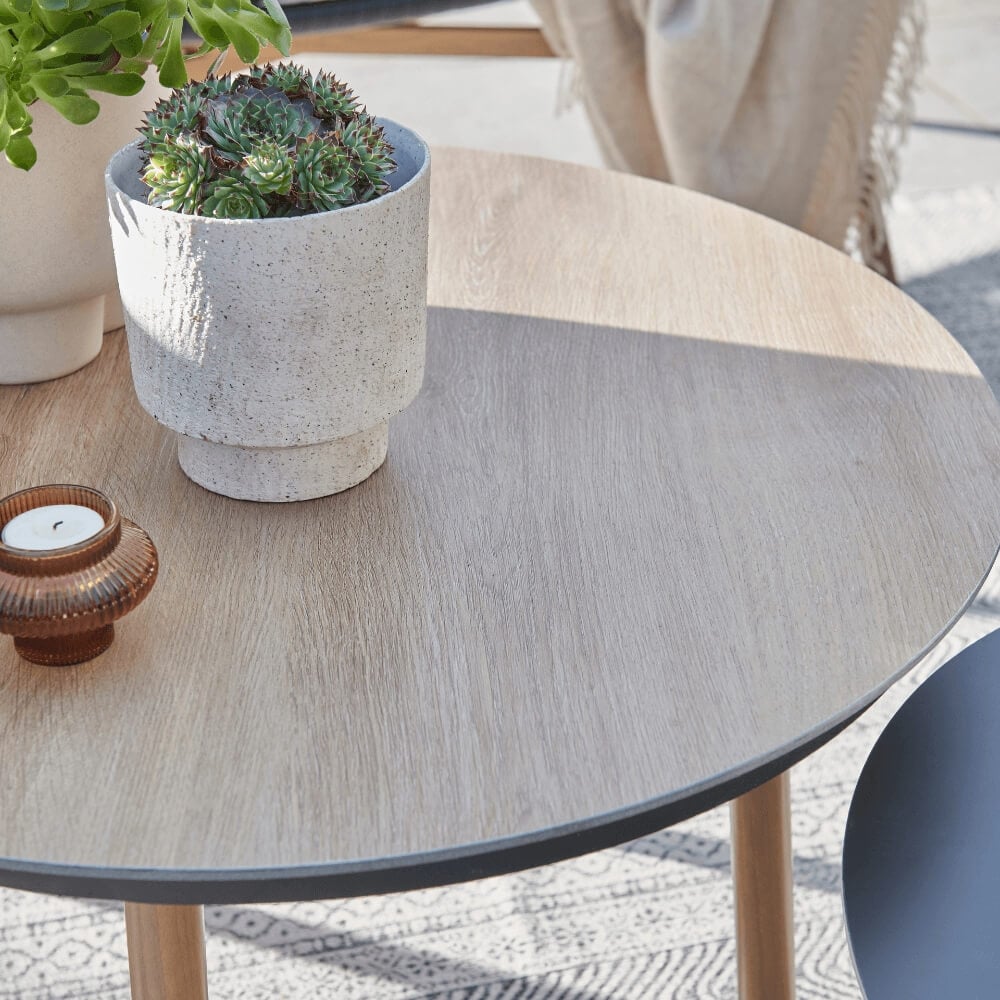 Small outdoor table sat on a patio with plants on it