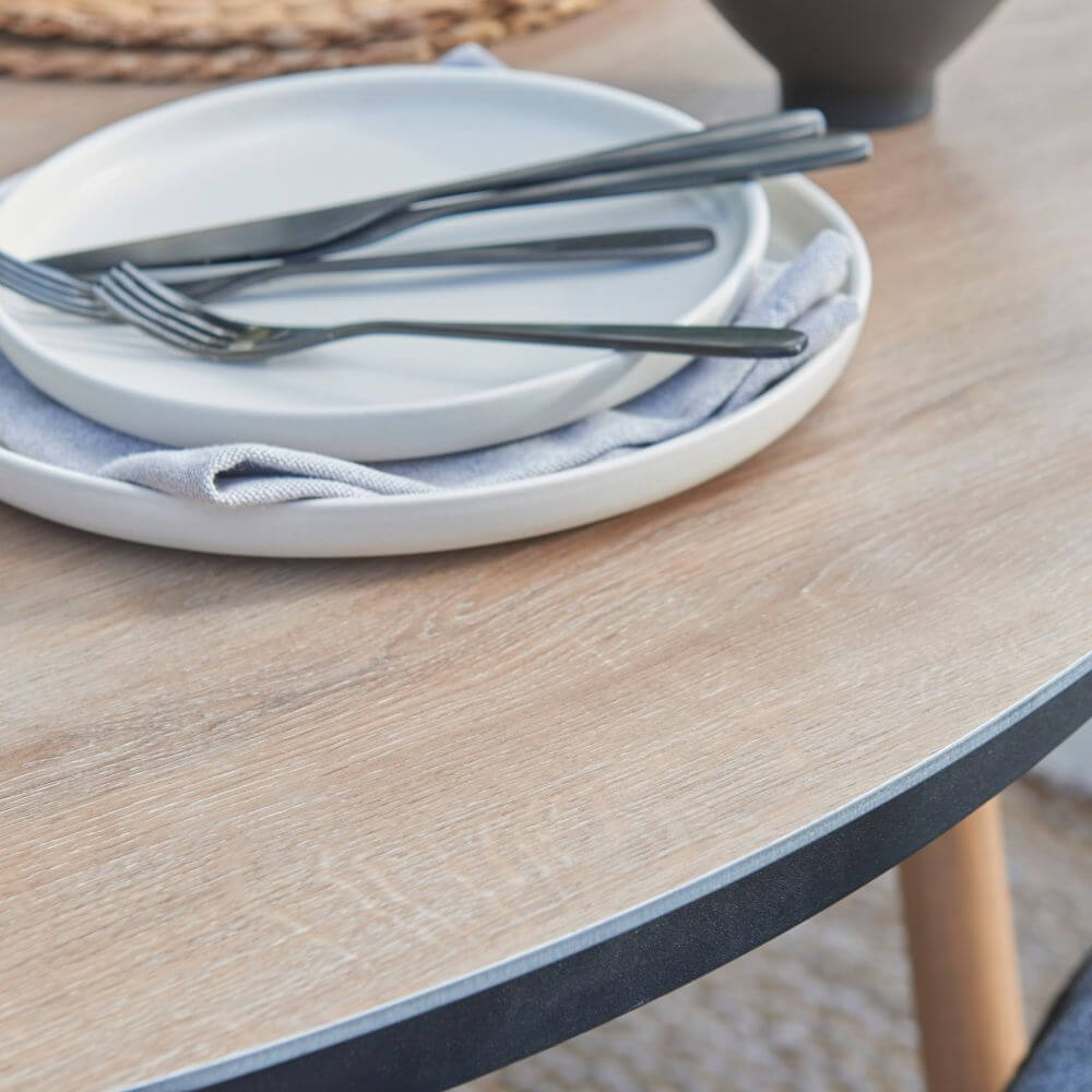 Modern wooden outdoor table with cutlery on it