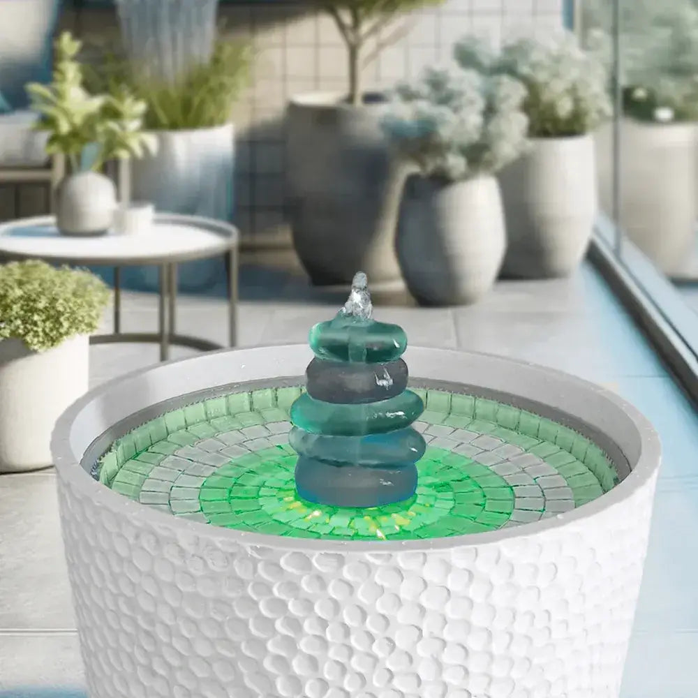 Hydria Decorative water fountain on a table with a garden view in the background