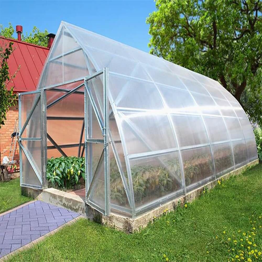 A large pointed greenhouse with doors open and plants inside