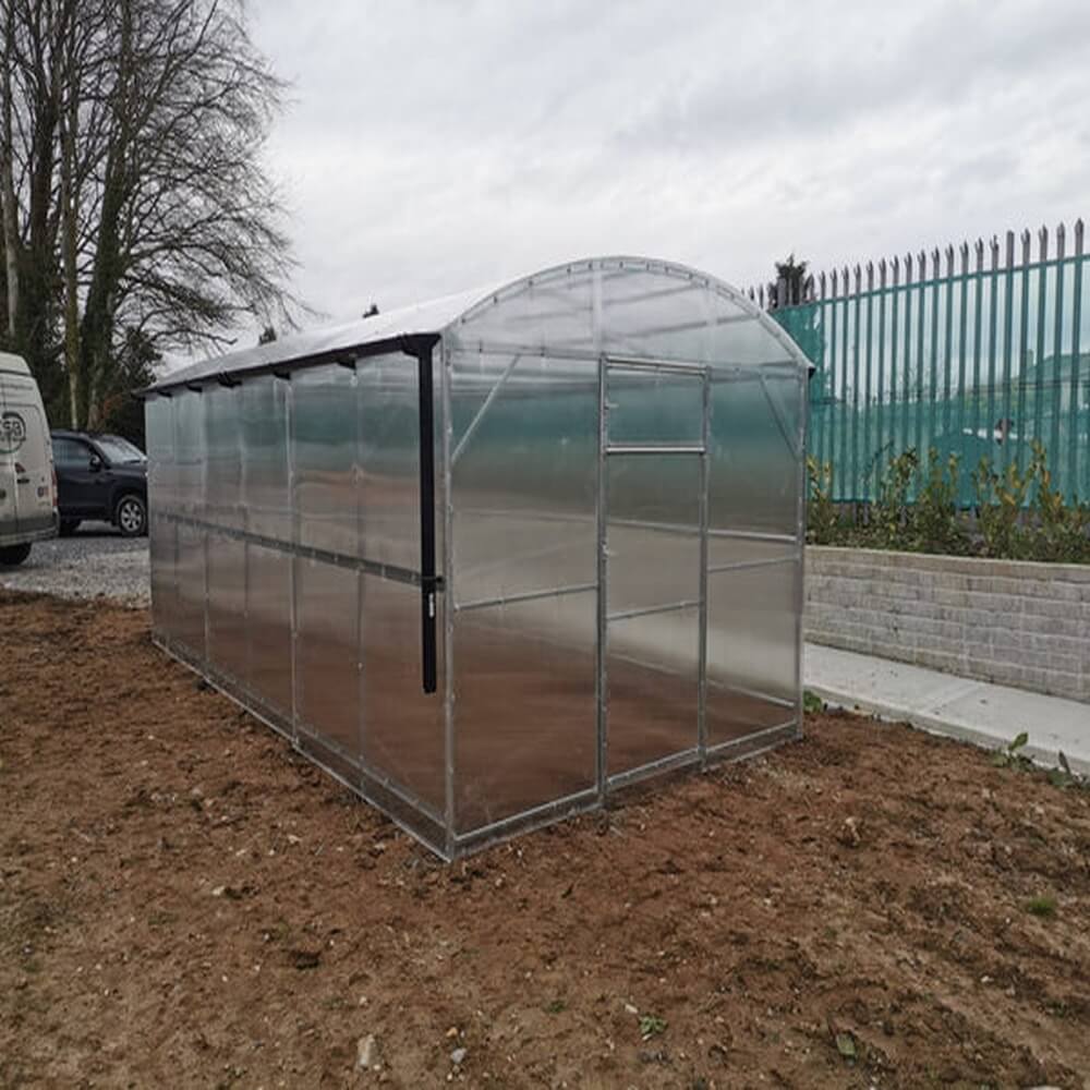 Side view of a greenhouse on a muddy area
