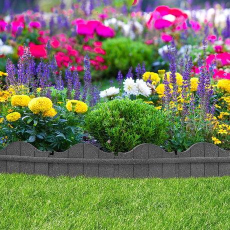 A dark grey, curved garden border made of rubber material, installed around a bed of colorful flowers.