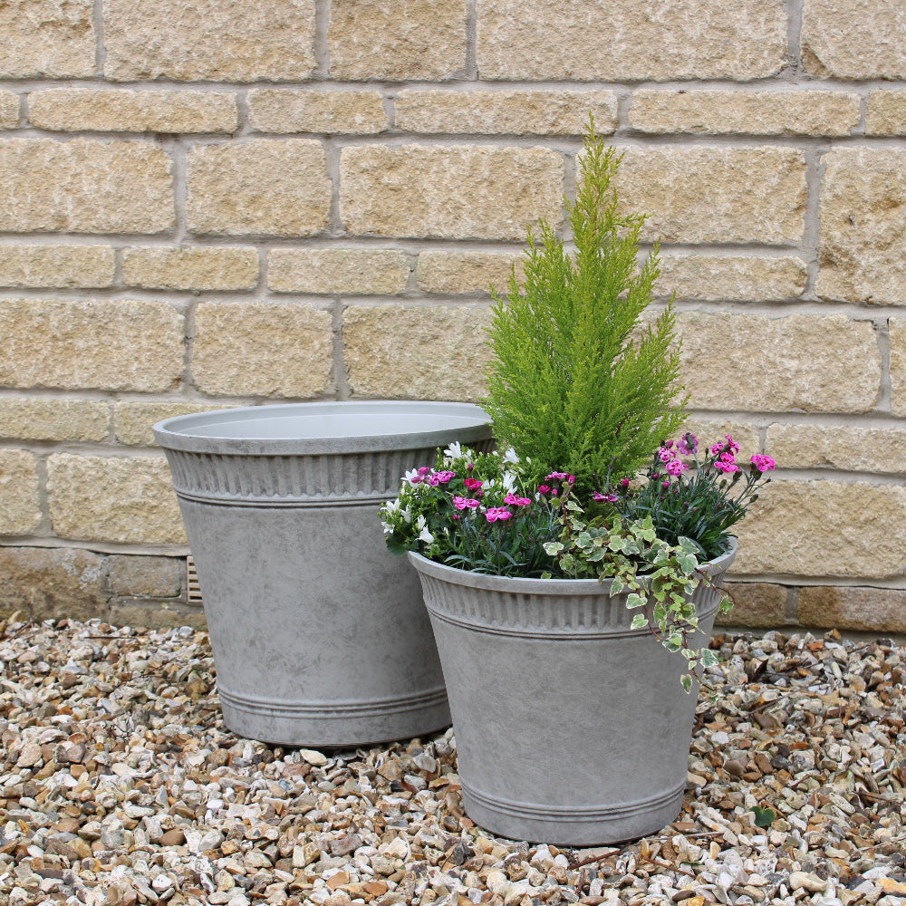 grey tostada planters in garden with plants in