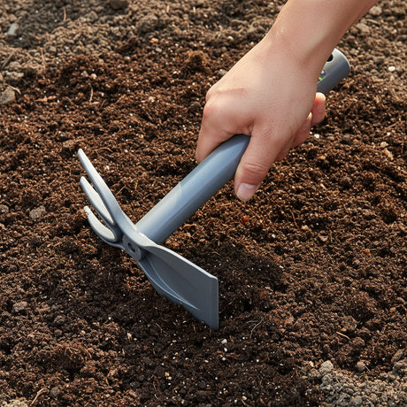 hand hoe being used to loosen soil in the garden