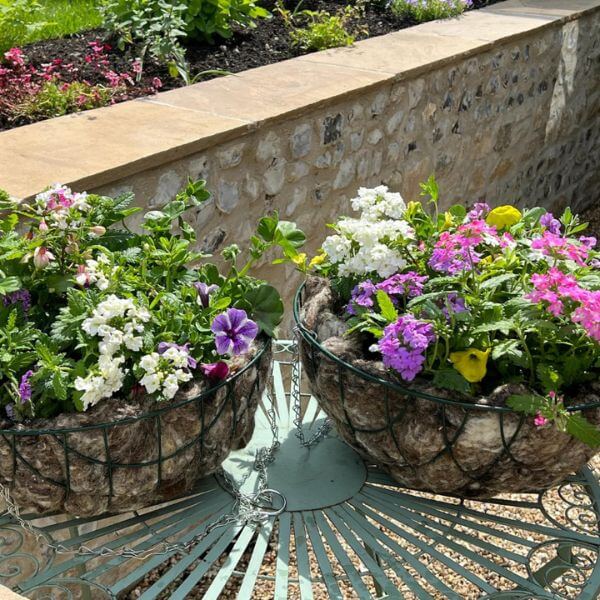 Showing the wool in  hanging baskets placed on a garden table in garden