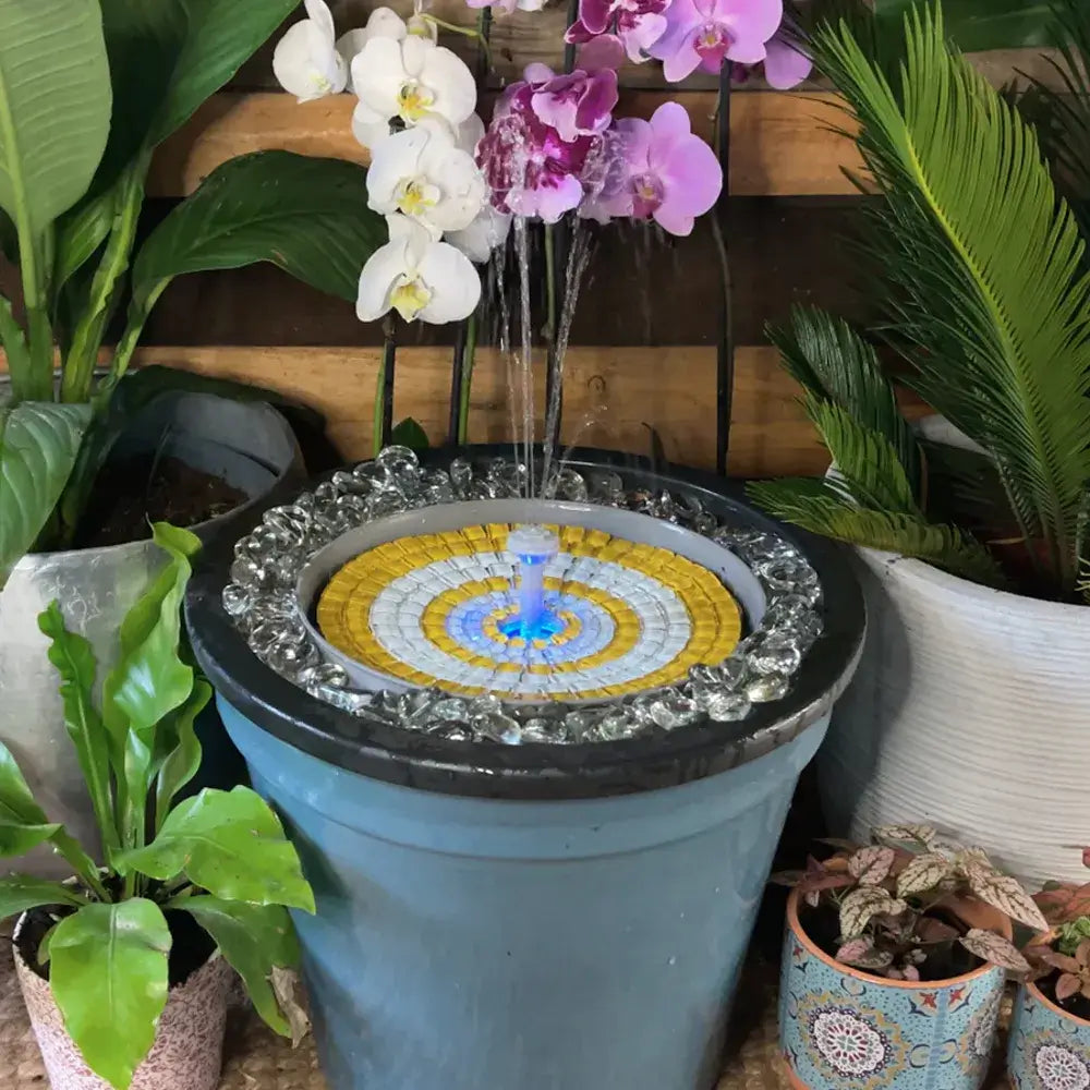 Decorative water fountain with mosaic design surrounded by potted plants