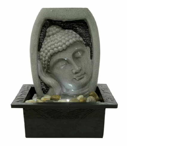 An indoor water feature depicting the head of a Buddha in a grey color, with water flowing around its base and an LED light positioned to illuminate the figure.