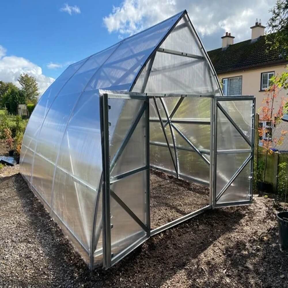 greenhouse with two doors open by a house