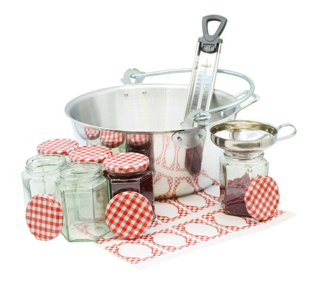 A set of kitchen utensils for making jams and chutneys, including a maslin pan, funnel, thermometer, and six glass jam jars with gingham labels.