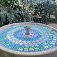 Mosaic water fountain surrounded by greenery