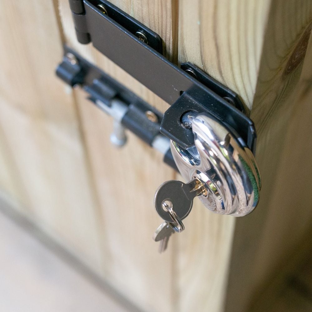 Top view of bolt lock secured with silver padlock and keys