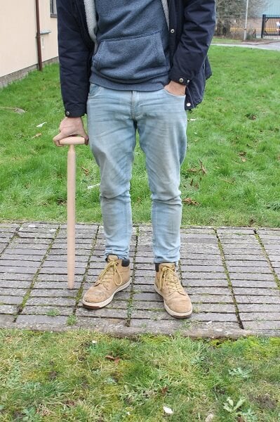 man holding wooden garden dibber