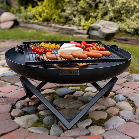 a black metal firepit style grill on diagonal legs on cobbled patio