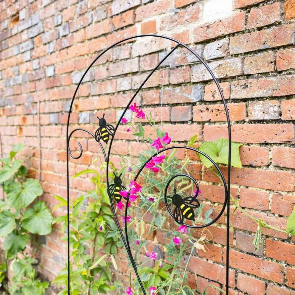 Metal trellis with bumble bee design in garden