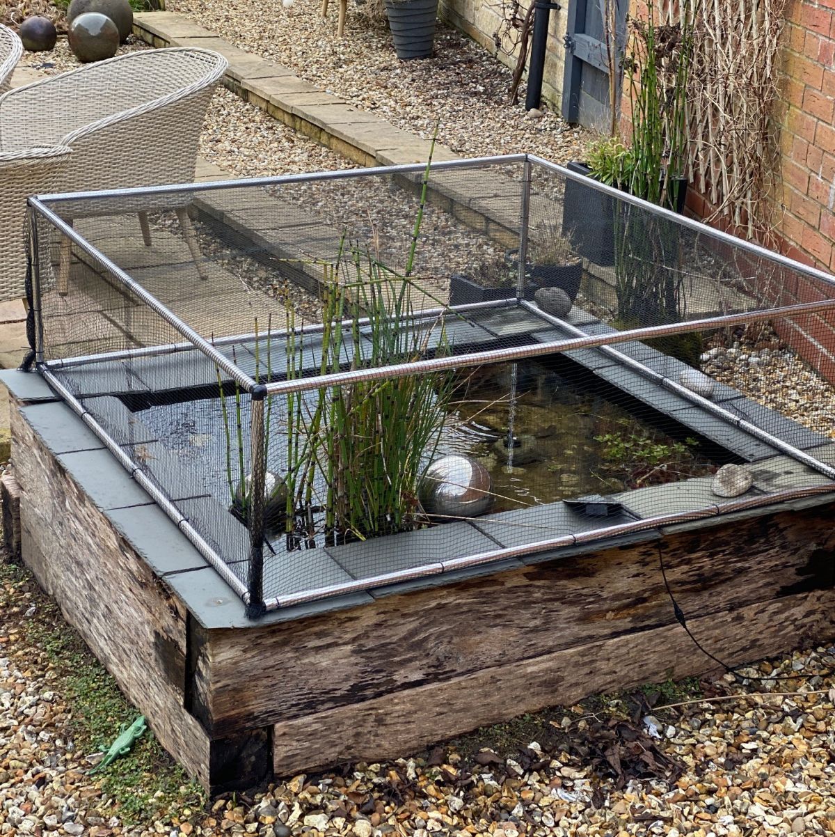 Showing netting over an aluminium frame on a pond