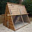 A wooden poultry house with a metal mesh run, designed for chickens, situated outdoors.