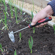 A person using a hand-held stainless steel onion hoe