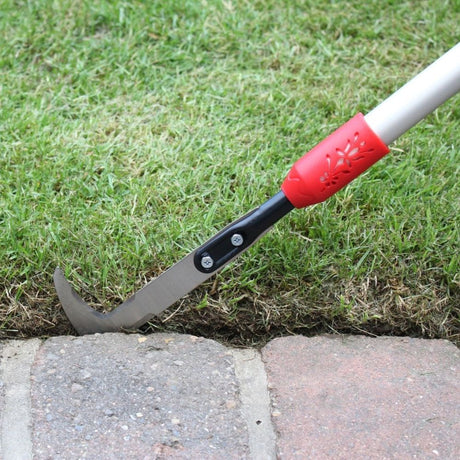 Darlac patio weeding knife being used on edge of patio and grass